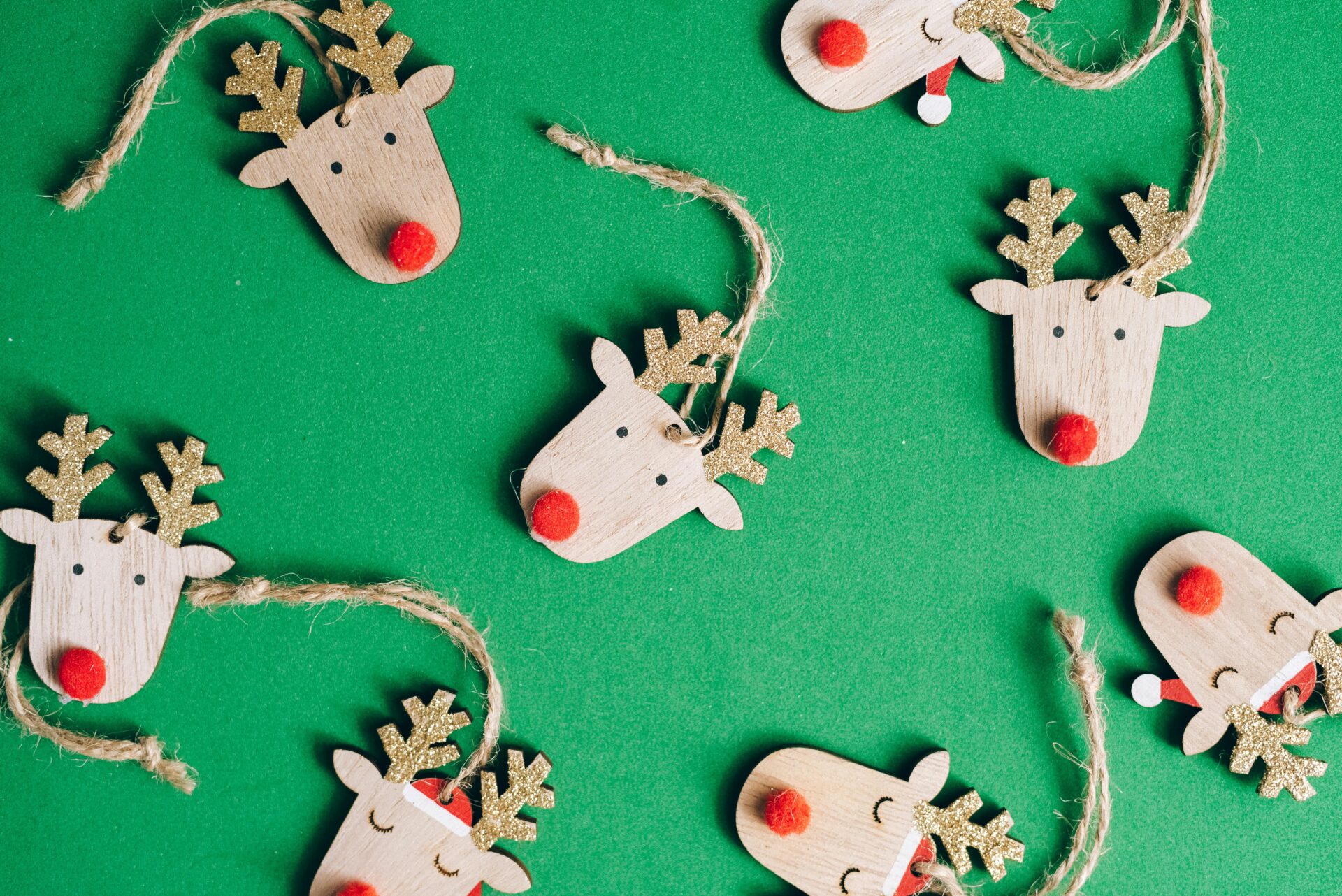 Wooden Christmas reindeer decorations on green background