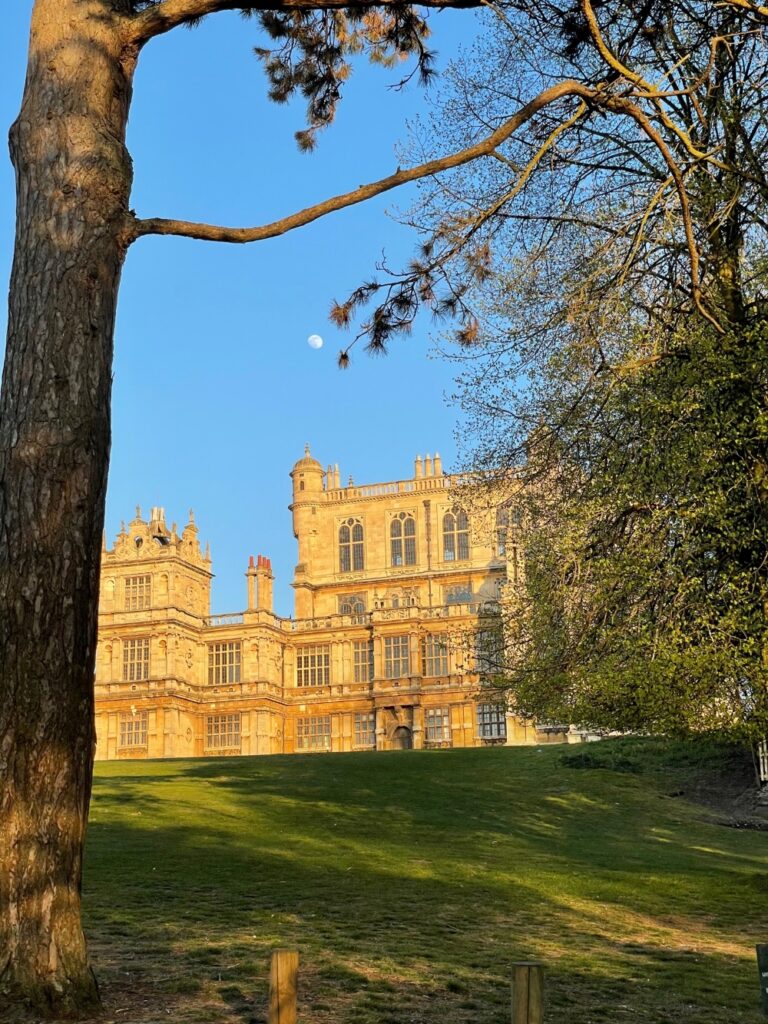 Wollaton Hall with moon in blue sky
